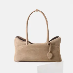 Vue de détail du sac cabas en daim avec texture en cuir premium et longues poignées.