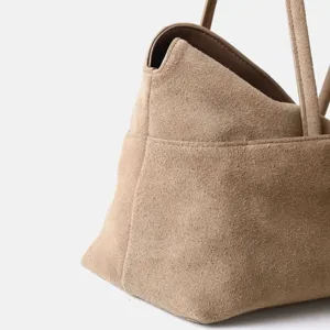 Gros plan sur le sac cabas en daim kaki pour femme, montrant la texture et les plis.