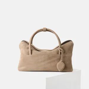 Vue détaillée du sac fourre-tout vintage en daim pour femmes avec poignées rondes douces.