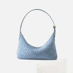 Gros plan sur le sac hobo en cuir tressé bleu clair montrant les détails de texture intrecciato exquis.
