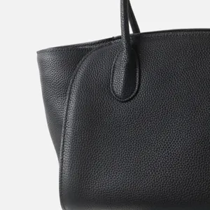 Gros plan détaillé du sac cabas en cuir véritable noir avec texture grainée et belle finition.