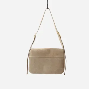 Détail de sac bandoulière en daim marron, design à rabat minimaliste avec sangle réglable.