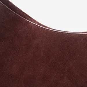Détail de sac à épaule en cuir suédé marron avec texture fine et coutures exquises.