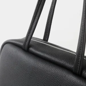 Gros plan sur le sac de bowling en cuir noir, texture grainée élégante, sac à main pour femme.