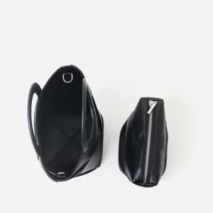 Minimalist black leather tote bag set with zipper pouch, chic geometric design for daily use.