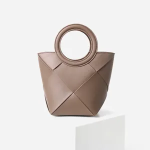 Brown woven leather handbag with circular top handle, stylish geometric tote bag for women.