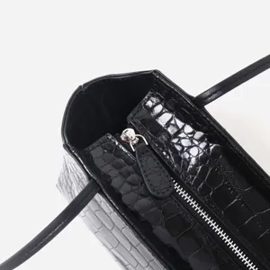 Black crocodile embossed leather tote bag detail view, chic commuting handbag with zip.