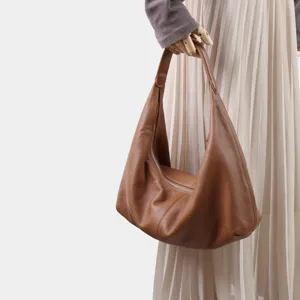 Vue détaillée du sac hobo souple en cuir de vachette marron avec bandoulière élégante.