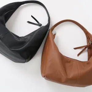 Vue de détail de sacs portés épaule souples en cuir noir et marron, usage quotidien.