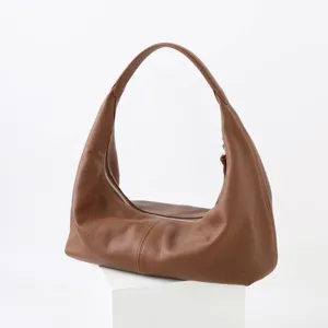 Détail de sac à épaule souple en cuir de vachette montrant la texture et la fermeture éclair.