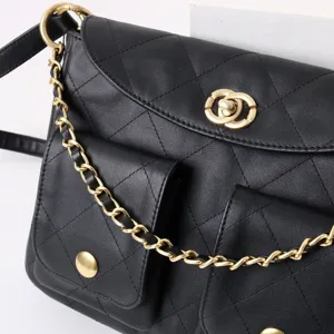 Sac bandoulière hobo matelassé en cuir noir avec quincaillerie dorée et poche avant.