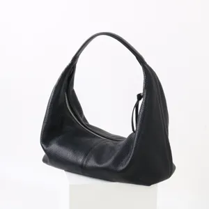 Gros plan sur la fermeture éclair du sac hobo en cuir souple noir, texture élégante.
