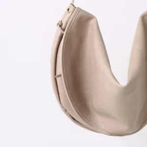 Vue détaillée d'un sac porté épaule minimaliste en cuir beige, style hobo décontracté chic.