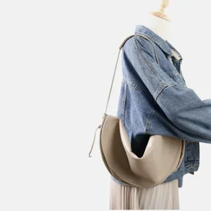 Vue détaillée d'un sac demi-lune minimaliste et souple porté sur un mannequin de studio.