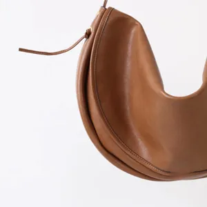 Vue detaillee du sac a main croissant en cuir marron, design minimaliste et elegant.
