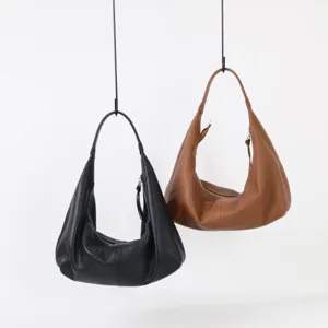 Gros plan détaillé du sac hobo en cuir souple montrant texture fine et fermeture zippée.