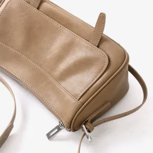 Détail de sac bandoulière rétro à rabat en cuir tanné végétal, sac sous les aisselles.