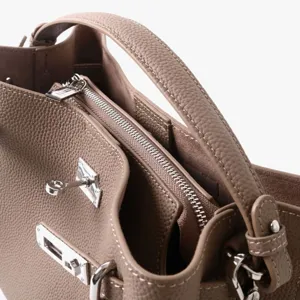 Gros plan détaillé d'un sac à main pour femme en cuir véritable avec serrure et fermeture éclair.