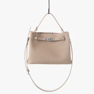 Détail de sac à main bandoulière en cuir véritable avec fermoir tournant en métal.