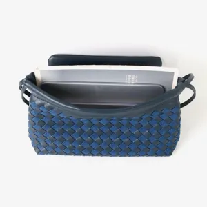 Vue détaillée de la pochette à rabat en cuir tressé bleu foncé avec belle texture.