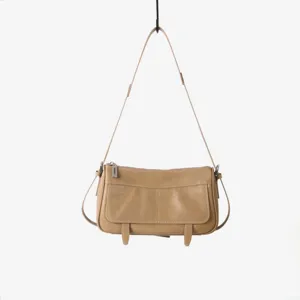 Détail en gros plan d'un sac à bandoulière en cuir vintage avec fermeture éclair et texture.