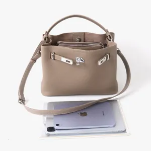 Détail de sac cabas bandoulière en cuir véritable, avec fermoir en métal et sangle réglable.