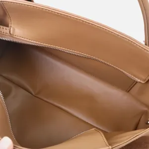 Détail intérieur de sac à main en cuir marron, doublure cabas élégante avec compartiment.