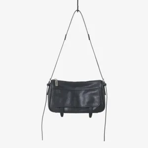 Vue détaillée du sac porté épaule en cuir noir avec rabat rétro et fermeture éclair métal.