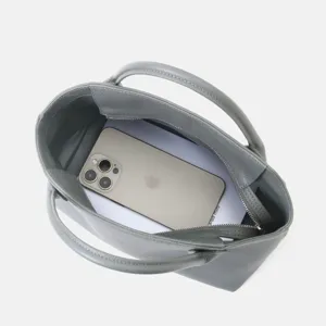 Vue détaillée de l'intérieur du sac à main en cuir gris montrant une grande capacité avec zip.