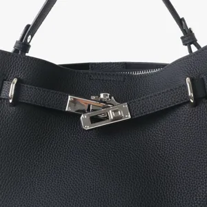 Gros plan d'un sac cabas en cuir noir avec fermeture à tourniquet et détails métalliques.
