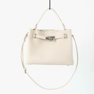 Gros plan sur les détails en cuir véritable de ce sac à main et ses finitions métalliques.
