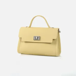 Gros plan détaillé de l'élégant sac à main en cuir jaune clair avec fermoir métallique.