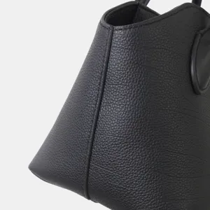 Gros plan détaillé du sac à main en cuir noir véritable avec texture fine et belles coutures.