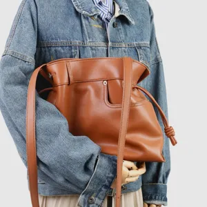 Sac porté épaule en cuir marron avec fermeture à cordon et détails de nœuds chics.