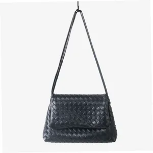 Sac porté épaule en cuir tressé noir avec rabat, design classique pour un style élégant.