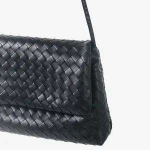 Gros plan détaillé du sac à main noir en cuir tressé mettant en valeur la belle texture.