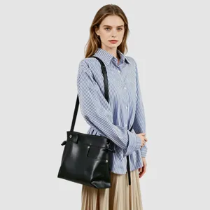 Vue détaillée d'un sac porté épaule en cuir souple noir avec sangle réglable et cordon de serrage.