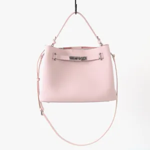 Détail de sac à main rose en cuir souple avec texture de vachette et fermoir en métal.
