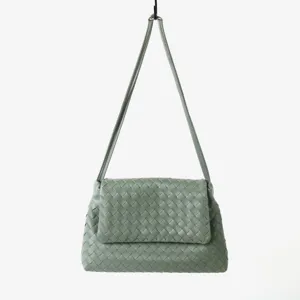 Vue détaillée du sac porté épaule en cuir tissé vert mettant en valeur la texture unique.