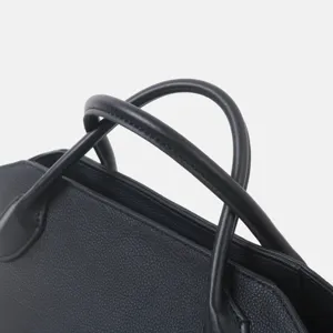Détail de sac à main noir en cuir de première couche, cabas élégant et classique.