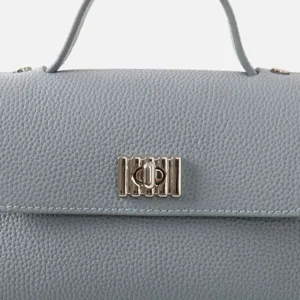 Gros plan détaillé d'un sac à main en cuir bleu clair avec élégant fermoir métallique.