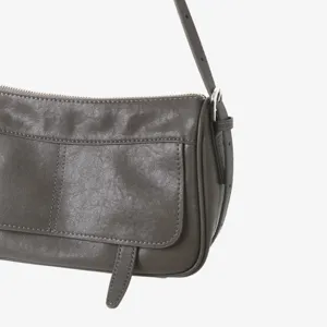 Détail du sac à épaule en cuir, design à rabat rétro, sac bandoulière avec fermeture éclair.