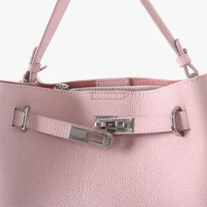 Détail de quincaillerie de sac à main en cuir rose, accessoire de gros plan de cabas en cuir.