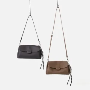 Vista detallada de bolso de hombro suave de cuero genuino para mujer con correa trenzada.
