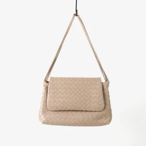 Gros plan détaillé du sac porté épaule en cuir tissé beige, texture tressée fine.