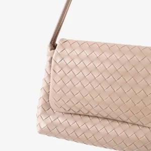 Gros plan detaille du sac a main en cuir tisse avec texture exquise et design elegant.