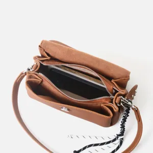 Detalle de bolso bandolera de cuero marrón con interior compartimentado y correa trenzada.