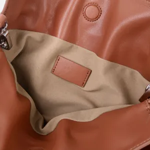Détail intérieur de sac hobo en cuir souple avec doublure en suédine et étiquette en cuir vierge.