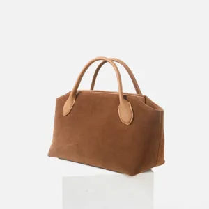 Vue détaillée du sac à main en daim marron avec poignées en cuir, style minimaliste élégant.