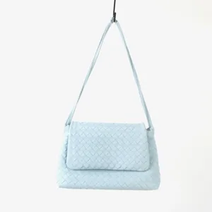 Vue détaillée du sac porté épaule en cuir tressé bleu clair avec finitions exquises.